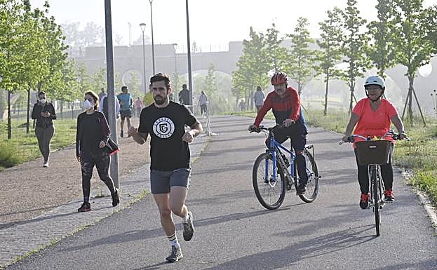 Corredores, ciclistas y paseantes en el parque del río en Badajoz. 