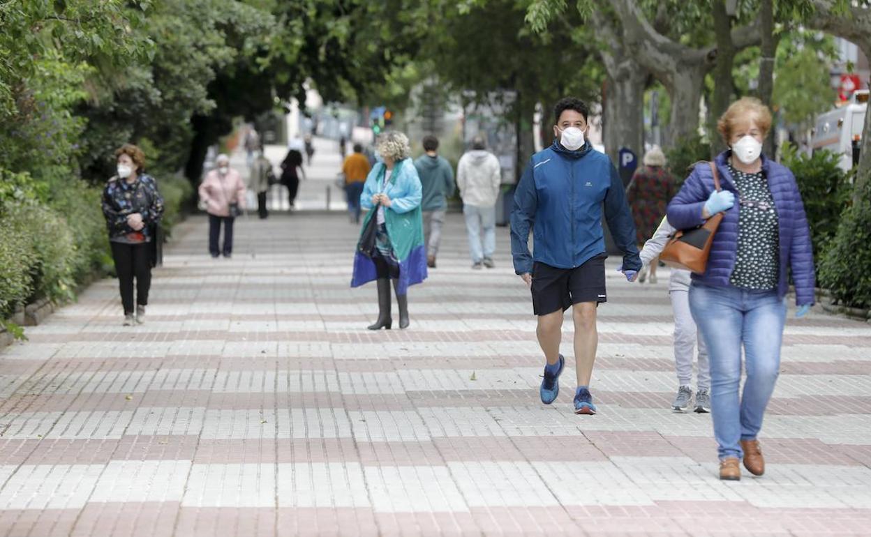 Varias personas pasean con mascarillas por la calle en Cáceres