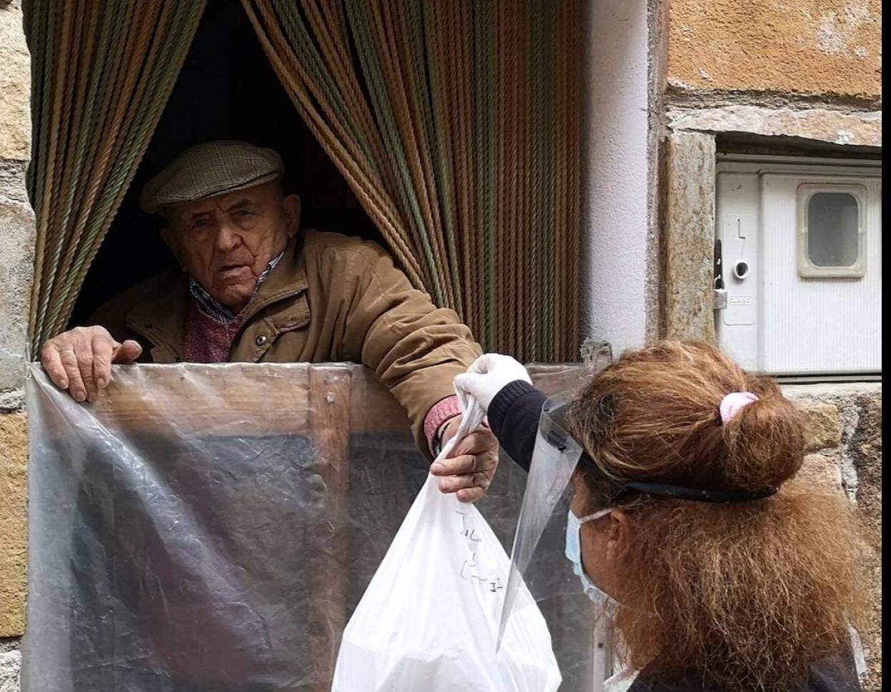 Entrega de comida a un vecino de la localidad cacereña.