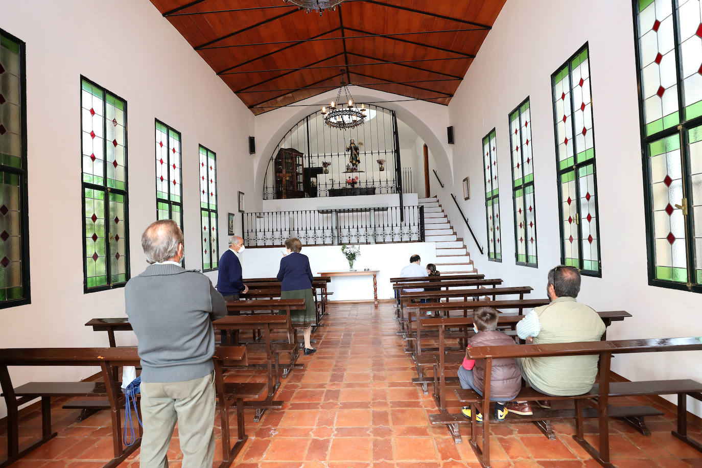 Un grupo de personas rezan en la ermita de Los Santos, en plena sierra de San Cristóbal, este viernes al mediodía.