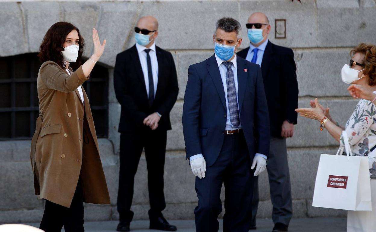 La presidenta de la Comunidad de Madrid, Isabel Díaz Ayuso, recibe el aplaso de los ciudadanos al término del minuto de silencio por las víctimas del coronavirus, en la Puerta del Sol.