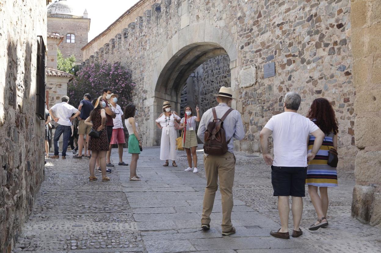 Turistas en el Arco de la Estrella de la Ciudad Monumental de Cáceres, ayer. 