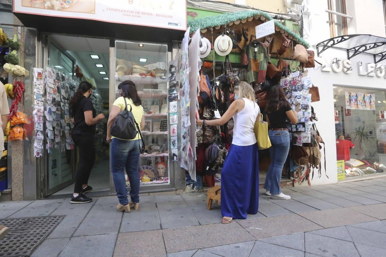 Algunas clientas observan y eligen artículos en dos establecimientos de la calle Santa Eulalia. 