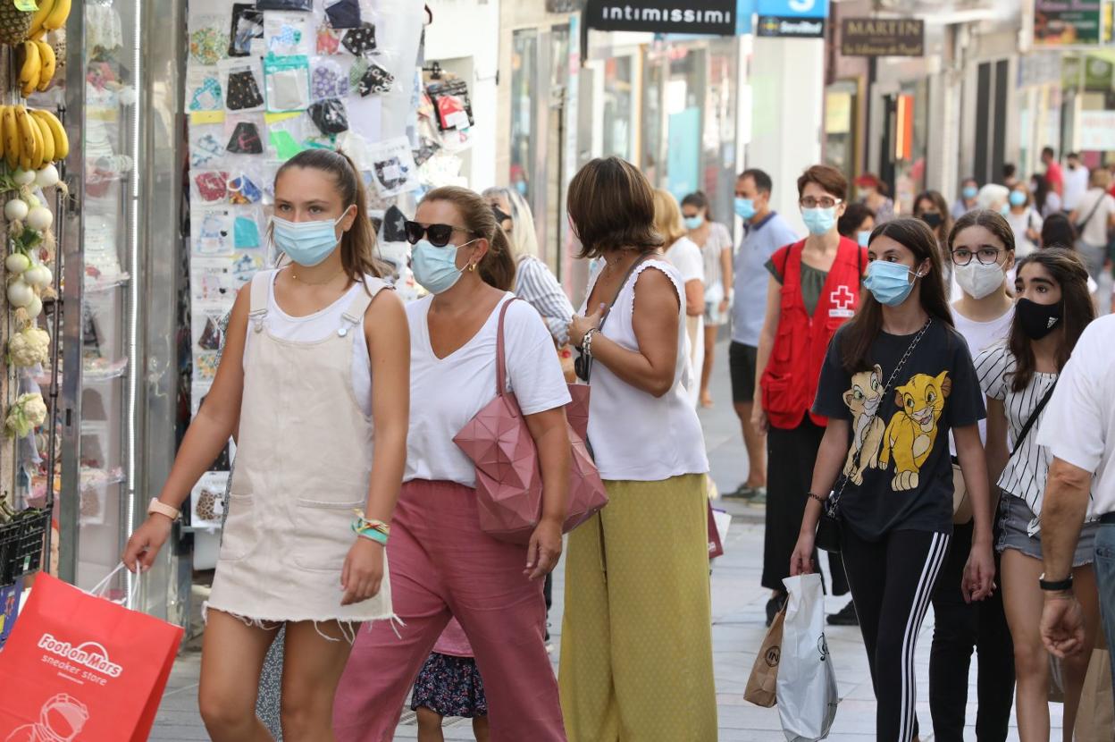 Gente paseando y de compras por la calle Santa Eulalia. 