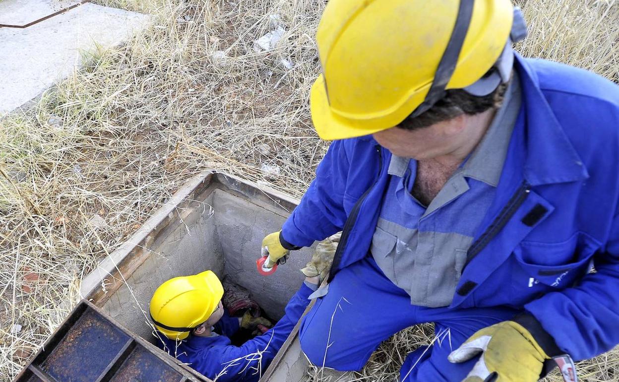 Dos trabajadores inspeccionan una instalación eléctrica.