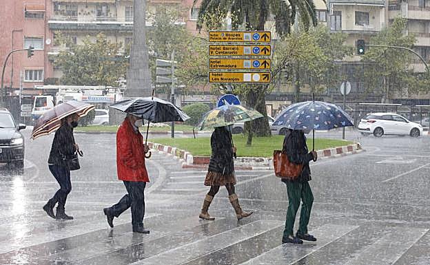 Peatrones agunatan el chaparrón en Cáceres.