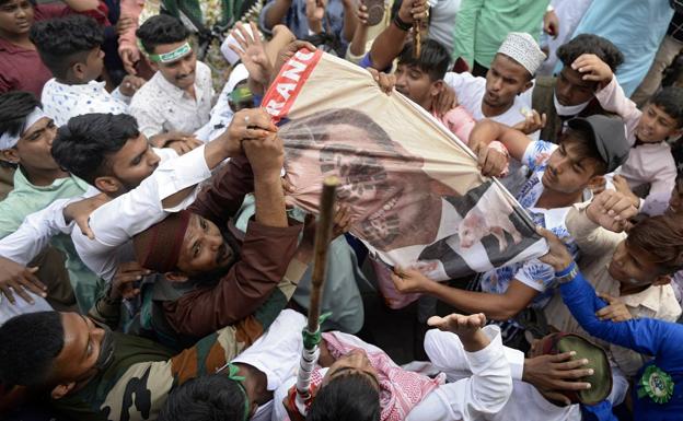 Un grupo de musulmanes destroza un cartel con el rostro de Macron en una localidad de India. 