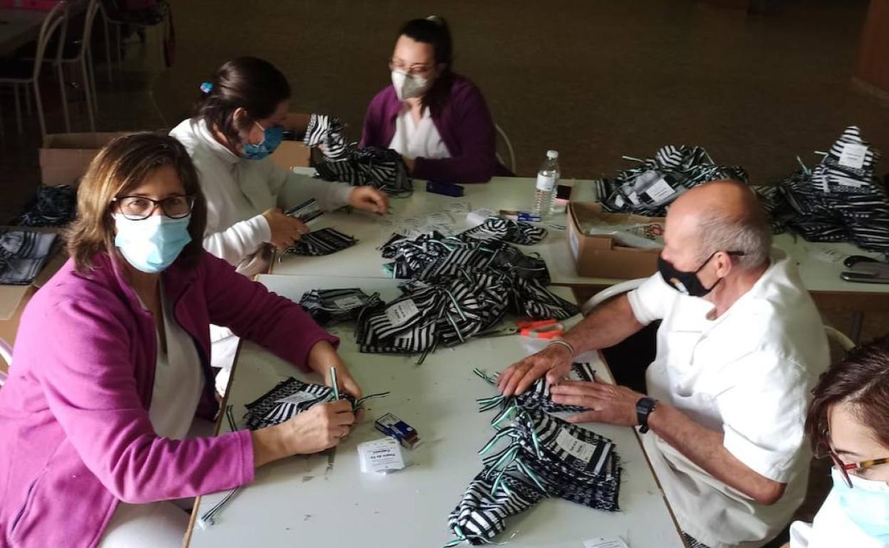 Trabajadores municipales en plena confección de las alforjas