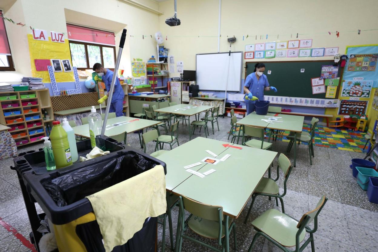 Limpiadores desinfectan un aula del colegio Trajano. 