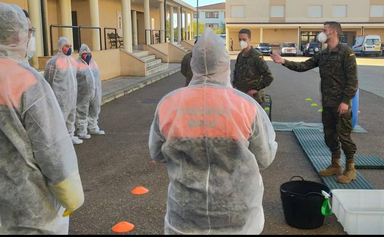 Militares de la Brigada Extremadura XI forman a voluntarios de Protección Civil en tareas de desinfección. 
