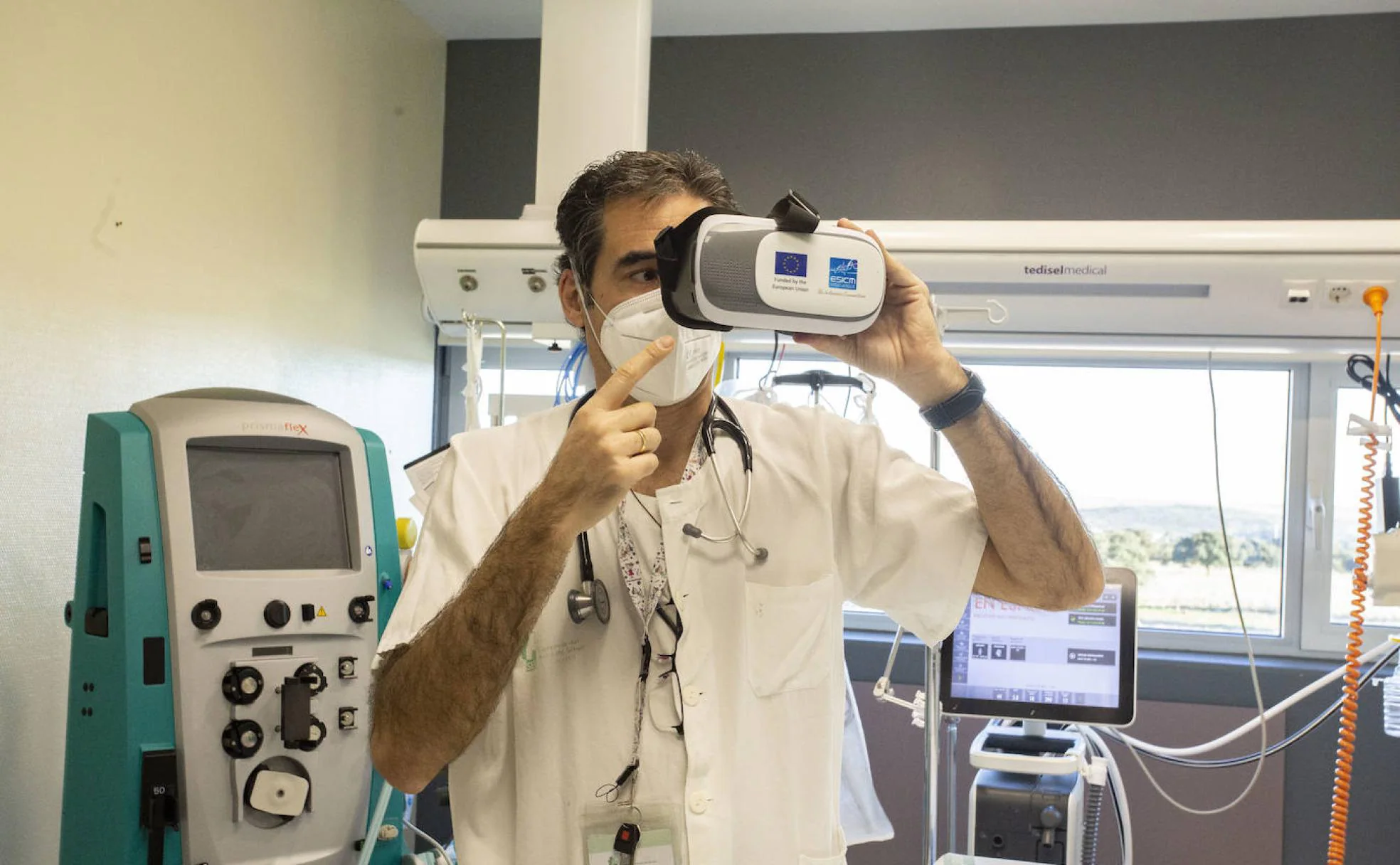 El anestesiólogo Fernando García-Montoto muestra cómo funcionan las gafas de realidad virtual desde un box de la UCI del hospital Universitario de Cáceres. 