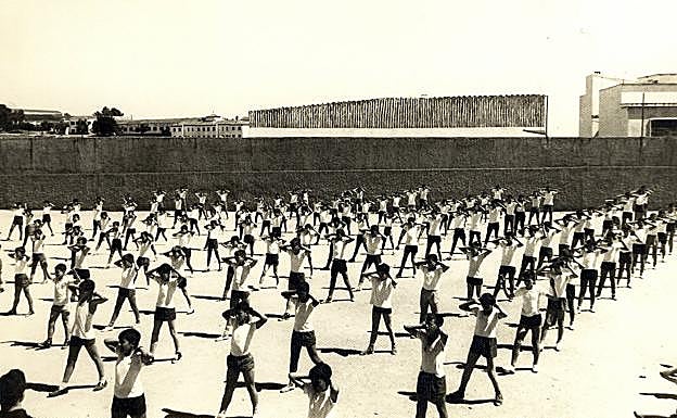 Imagen principal - Arriba, grupo de alumnos del curso 1963-64 en la clase de gimnasia que se daba en las pistas deportivas anteriores a la construcción del pabellón deportivo, situadas donde hoy está el Hotel Don Manue; aajo a la izquierda, clase de 4º de Primaria del curso 95-96 con los primeros uniformes escolares; y a la derecha,e n el centro de la imagen, Pedro Almodóvar con tres compañeros. 