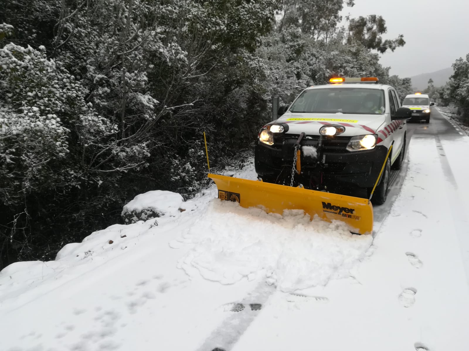 Un vehículo retira la nieve en la carretera CC 20.2 Villar del Pedroso a ex 118