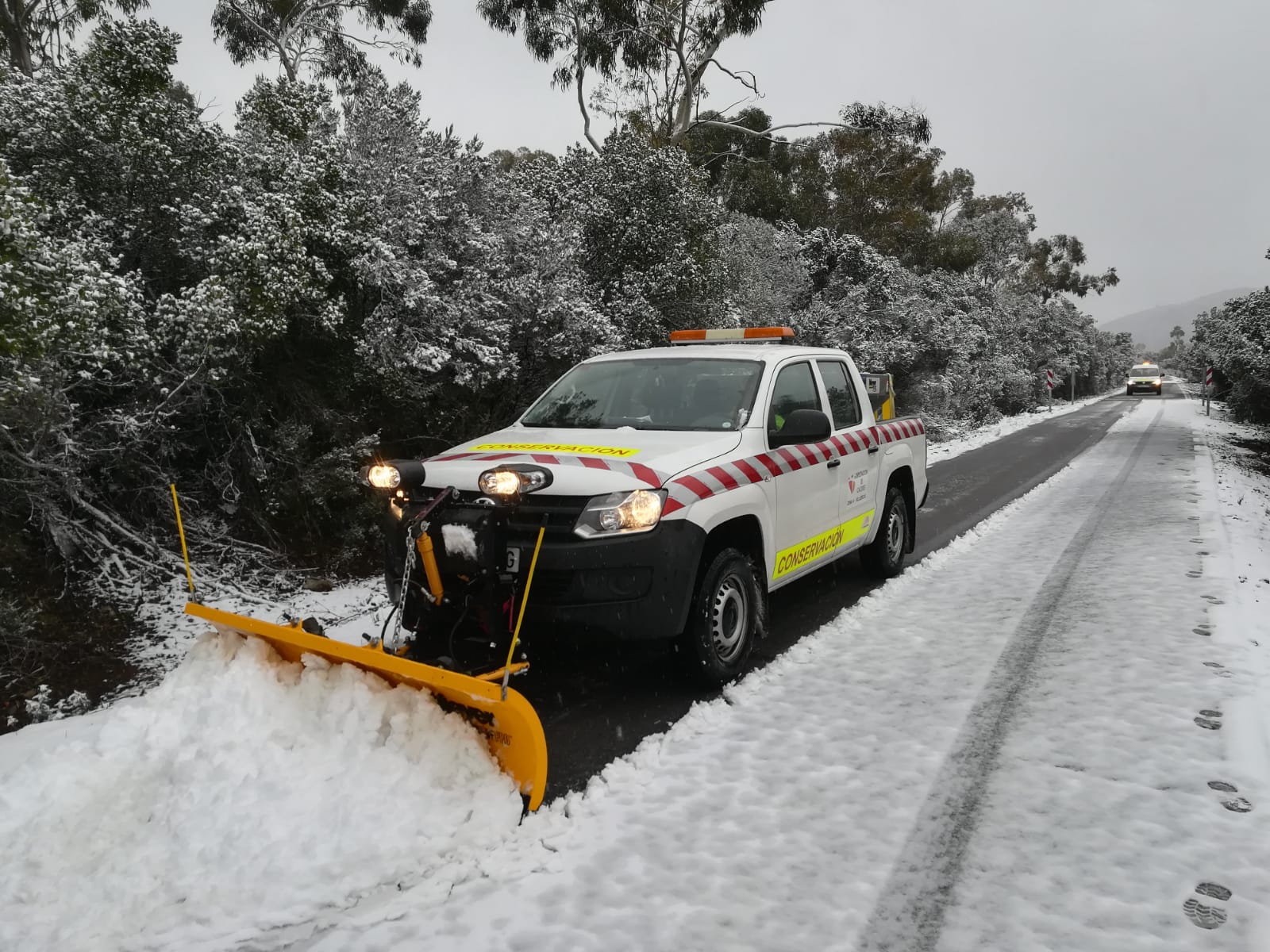Un vehículo retira la nieve en la carretera CC 20.2 Villar del Pedroso a ex 118