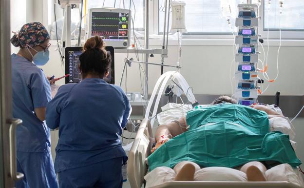Dos enfermeras atienden a un paciente en la UCI del Hospital Reina Sofía de Murcia.