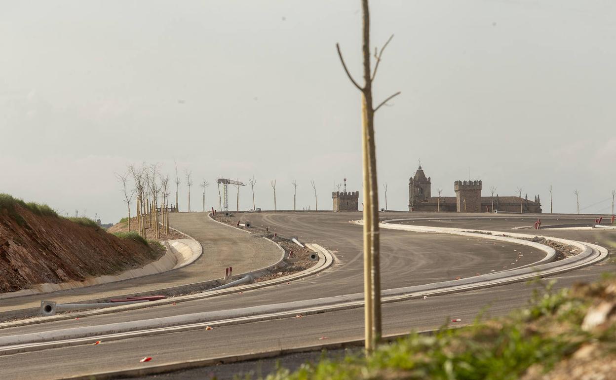 Árboles plantados a ambos lados de la vía, con la Ciudad Monumental al fondo. 