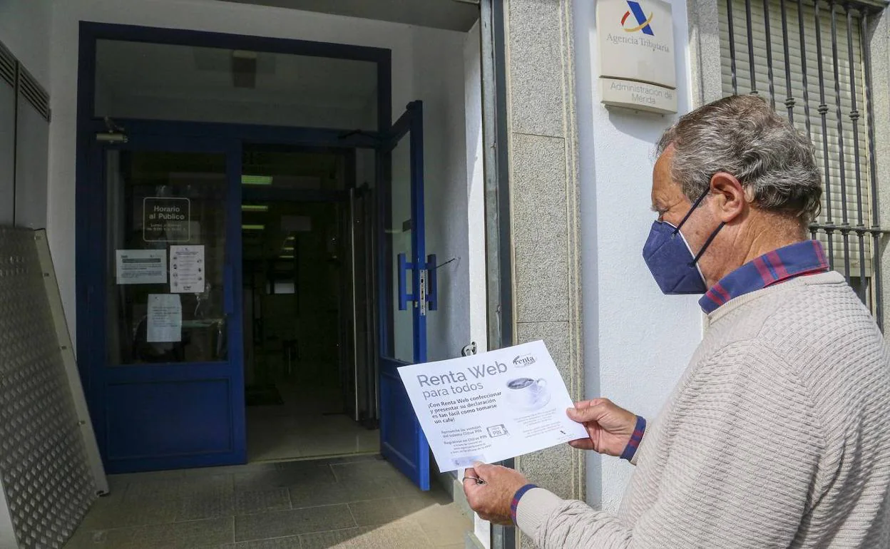 Una persona ante la Agencia Tributaria en Mérida con información sobre la tramitación por Internet.