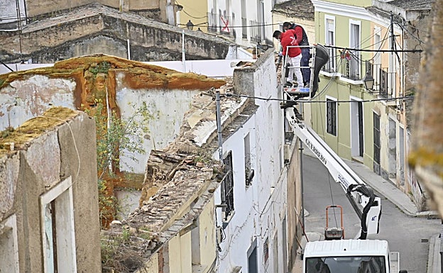 Dos operarios trabajando en el derribo de la fachada del número 42. 