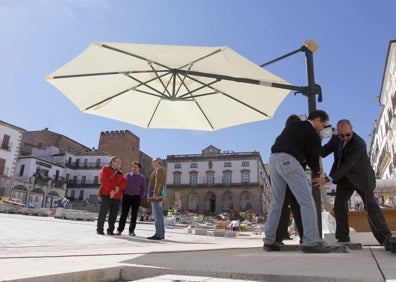 Imagen secundaria 1 - El director de la reforma, Antonino Antequera, en la plaza. Los hosteleros colocan las sombrillas días antes de la apertura (abajo a la izquierda) y portada del suplemento que publicó HOY en abril de 2011. 