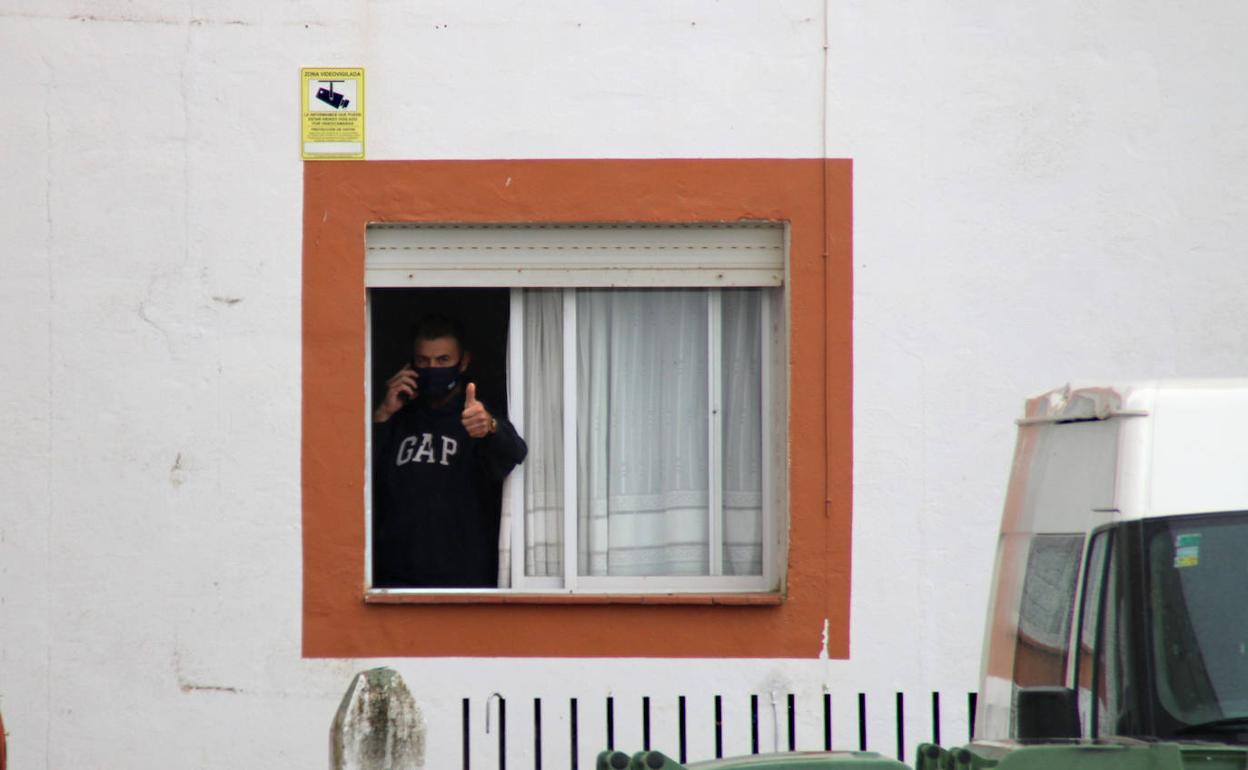 Uno de los esquiladores en aislamiento en Navalvillar de Pela saluda desde la ventana. 