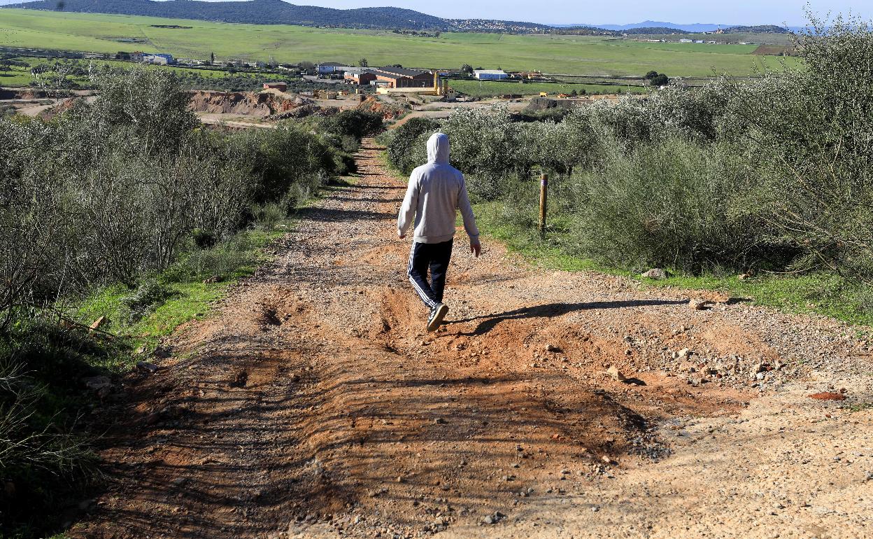 Un hombre pasea por un camino en mal estado por las inmediaciones de la Sierra de la Mosca. 