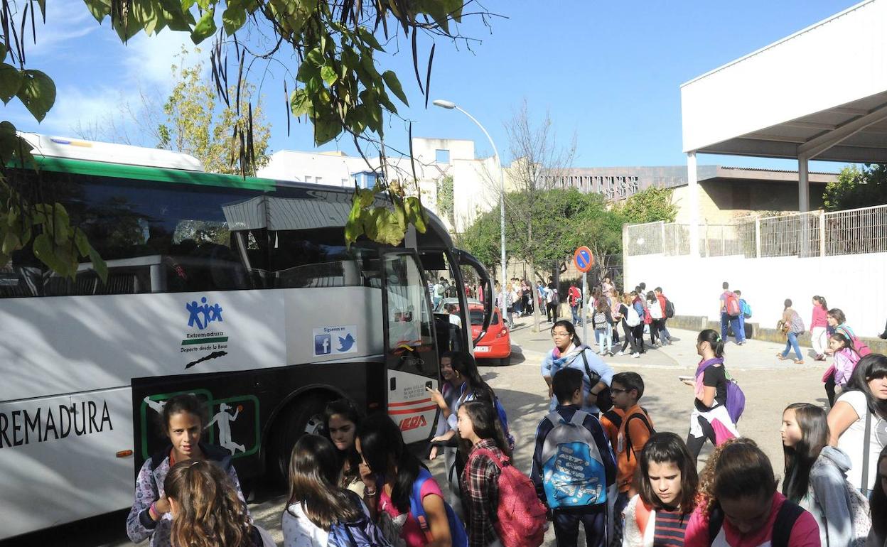 Estudiantes acceden a un autobús de una ruta de transporte escolar. 