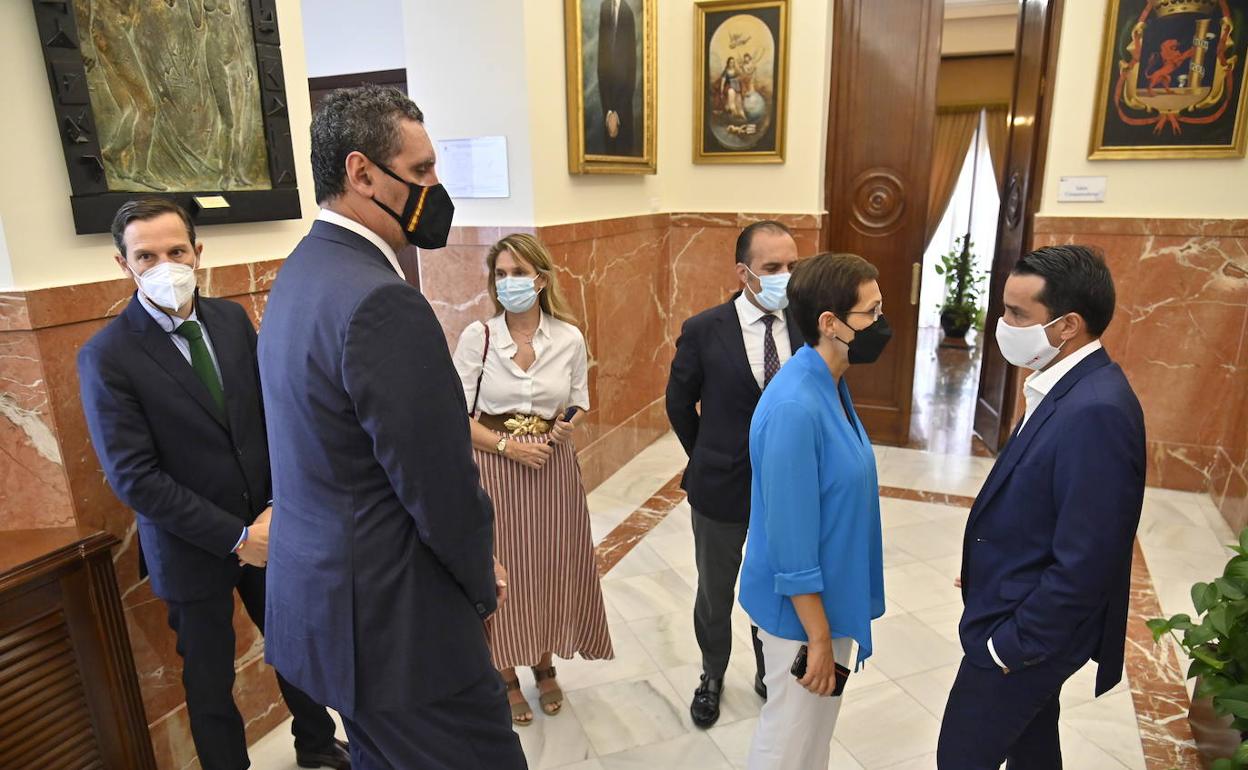 La concejala del PP, María José Solana, vestida de azul, habla con Cabezas antes de que comience el pleno rodeados de concejales del PP. 