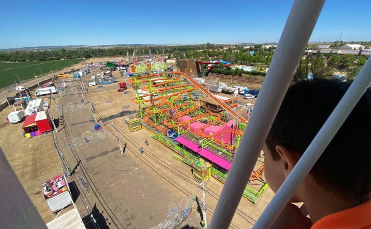 La noria funcionando delante de muchas atracciones desmontadas. 