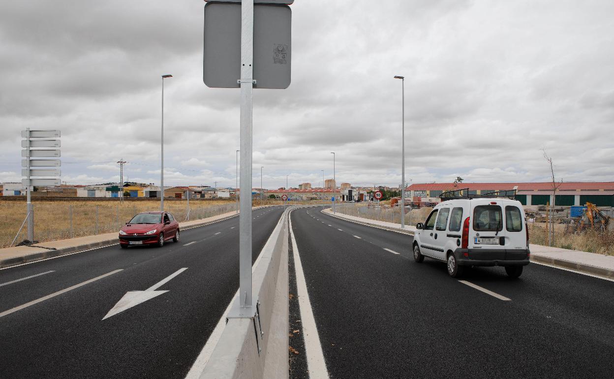 Dos coches se cruzan en la nueva doble vía de acceso a Cáceres, que cuenta con acerado para los viandantes e iluminación. 
