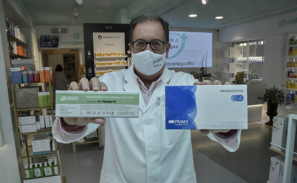 Cecilio Venegas, presidente del Colegio de Farmacéuticos de Badajoz, muestra dos marcas de test que se comercializarán en Extremadura. 