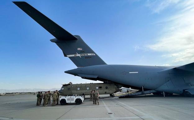Un helicóptero CH-47 Chinook estadounidense es cargado en un avión de transporte C-17 en el aeropuerto de Kabul, uno de los últimos en despegar este lunes.
