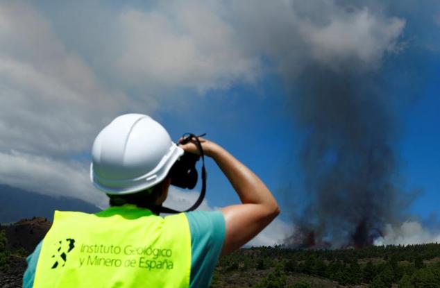 Un miembro del Instituto Español de Minería Geológica observa el aumento de humo tras la erupción.