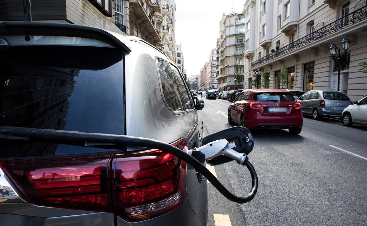 Un vehículo eléctrico enchufado en un punto de recarga. 