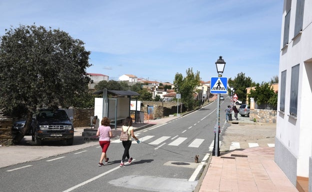 Calle principal de Botija. A la izquierda, la parada del bus.