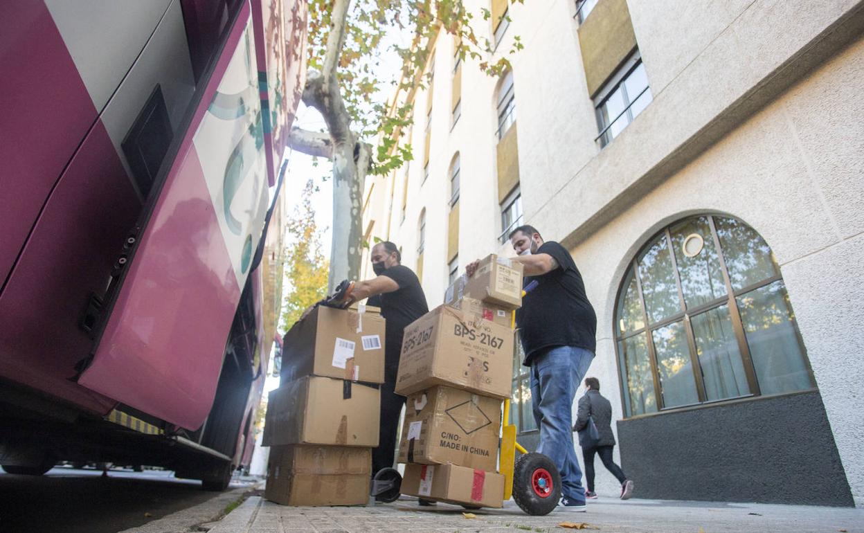 Operarios sacando cajas del autobús durante el traslado a Ciudad Jardín en Cánovas. 