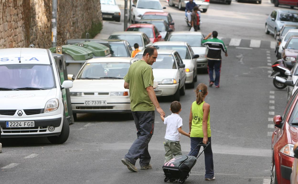Un padre llevando a sus hijos al colegio en Cáceres 