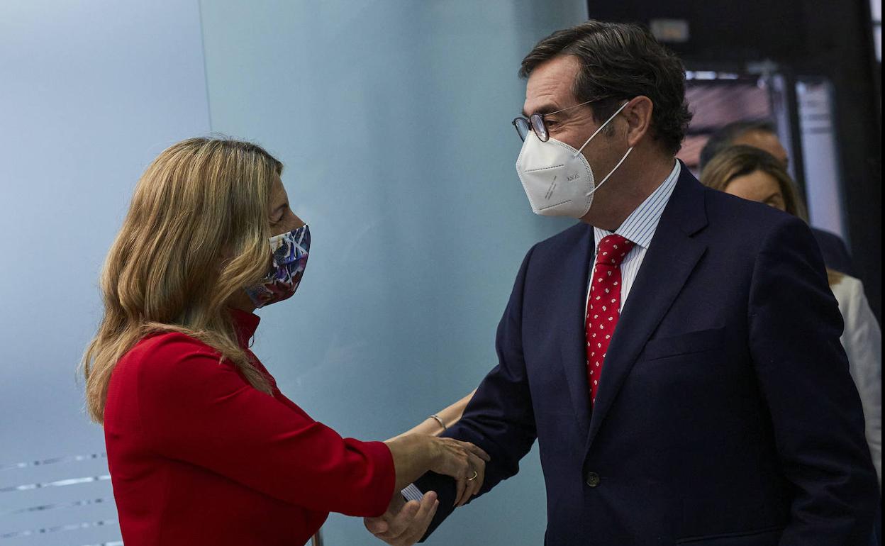 La ministra de Trabajo, Yolanda Díaz, saluda al presidente de la CEOE, Antonio Garamendi.