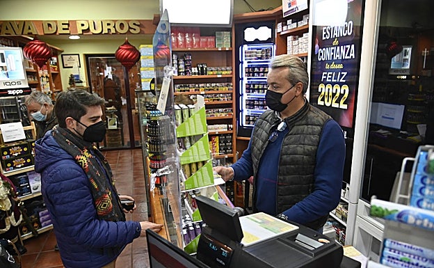 Alejandro Fernández despacha a un cliente en su estanco de la calle pacense de Vasco Núñez. 