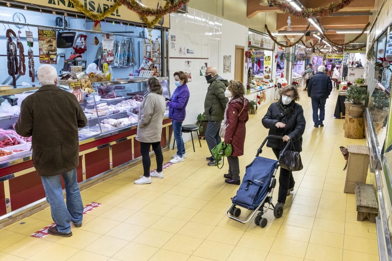 Clientes en algunos de los puestos de venta que hay en el mercado de abastos. 