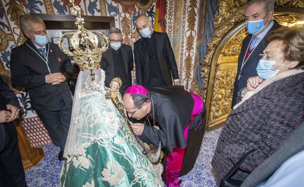 El obispo besa el manto de la Virgen de la Montaña durante su visita al Santuario. 