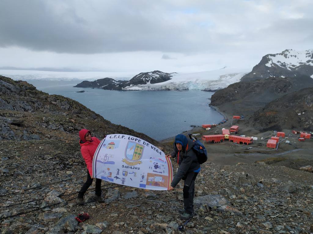 Científicos en la Antártida con la bandera del colegio Lope de Vega.