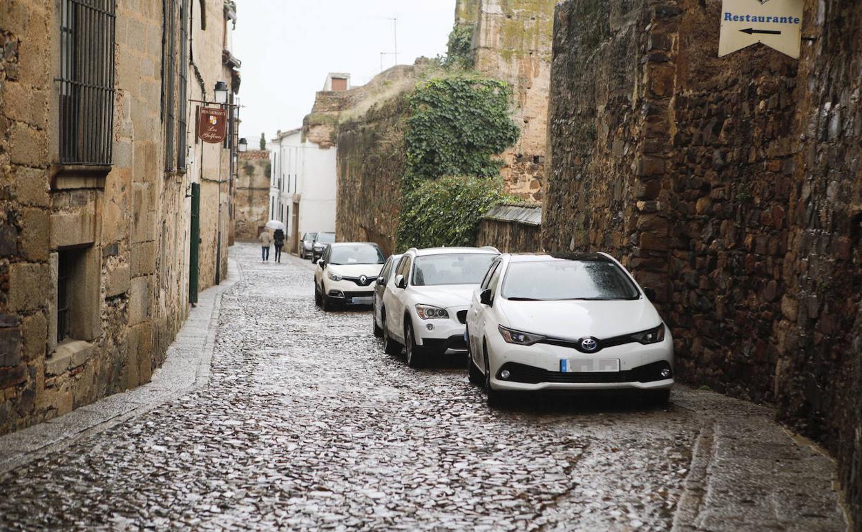 Coches aparcados en uno de los adarves de la parte antigua de Cáceres. 
