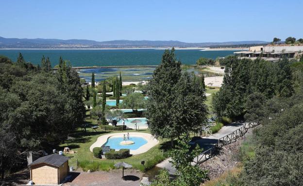 Zona de playa artificial del complejo, con el embalse al fondo. 