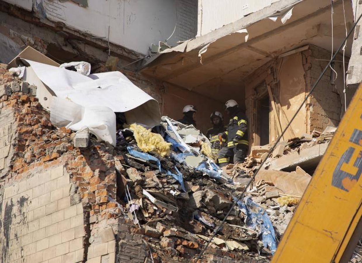 Bomberos ucranianos trabajan dentro de un edificio dañado después de un bombardeo en Kharkiv, Ucrania.