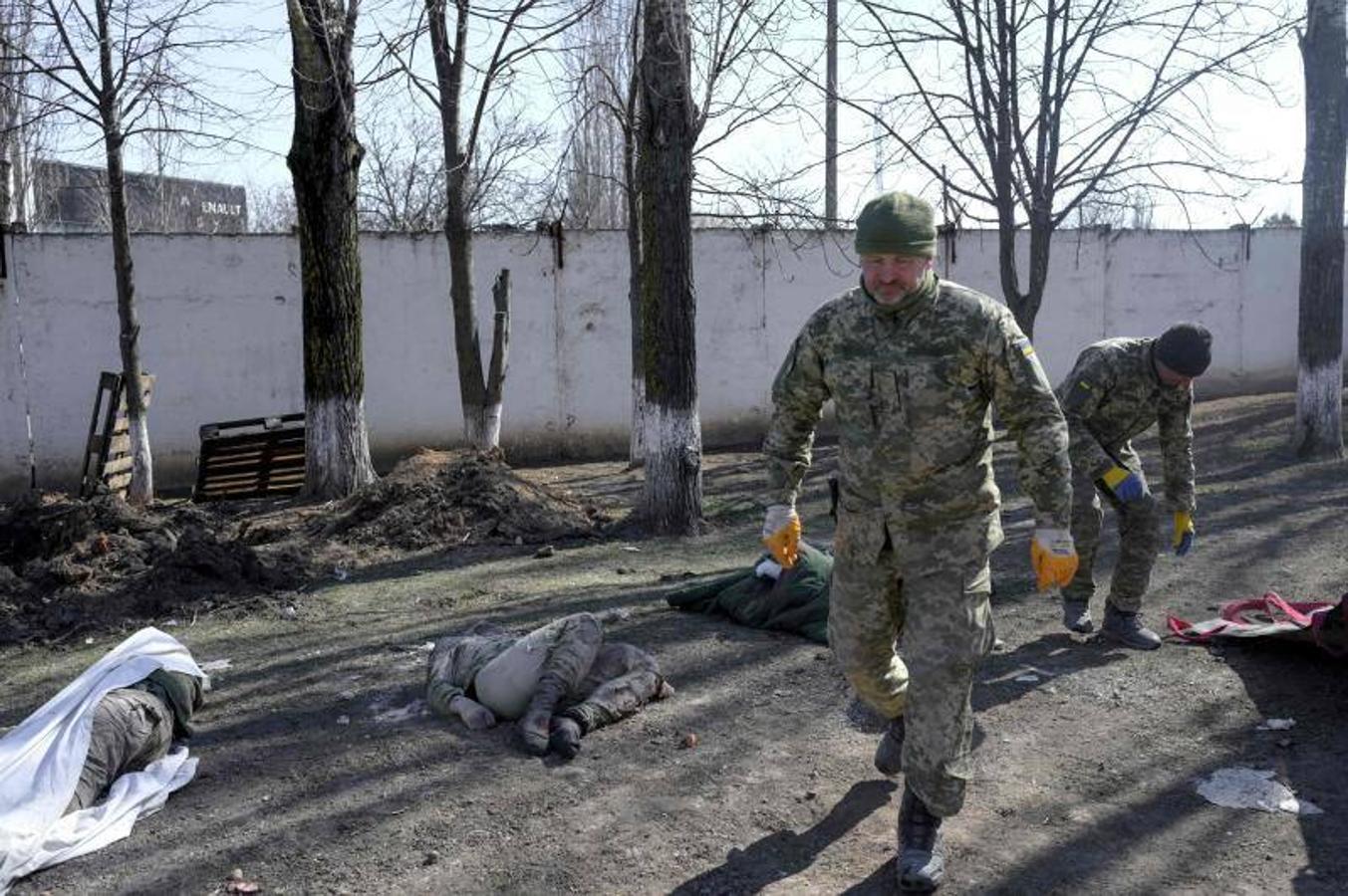 Soldados ucranianos caminan entre los cuerpos de víctimas del ataque en la escuela militar de Mykolaiv.