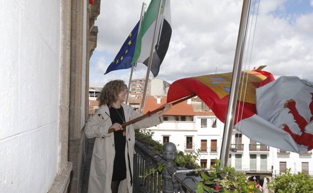 La concejala de Juventud Paula Rodríguez ha tremolado el pendón desde el balcón del Ayuntamiento de Cáceres. 