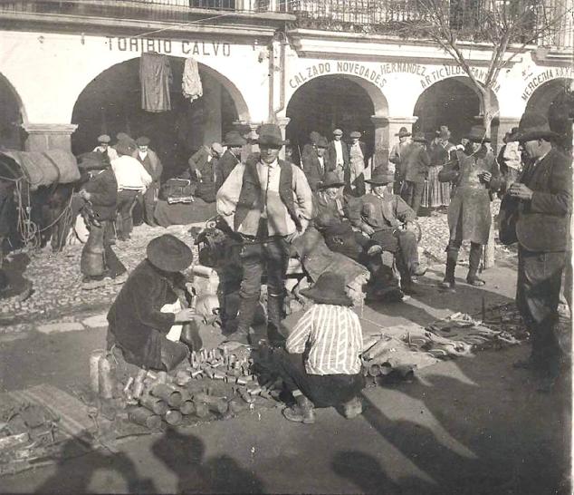 Particular fotografía del hijo del pintor del mercado del martes de Plasencia, en la que en la parte inferior aparecen las siluetas de él tomando la foto y la del padre con su sombrero. 