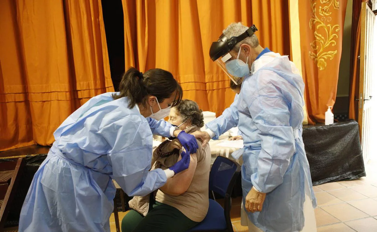 Una enfermera administrando una dosis a una persona mayor al inicio de la campaña de vacunación. 