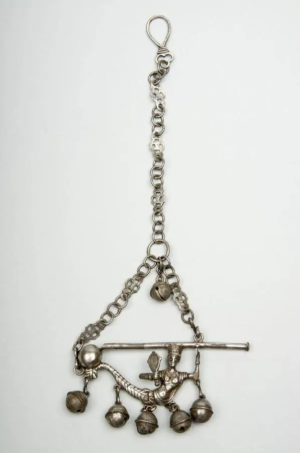 Sonajero de plata del siglo XVII que se utilizaba en Extremadura para que los niños que lo llevaban no se murieran. Es una sirena coronada ante un espejo, que además de cascabeles tiene un silbato. 