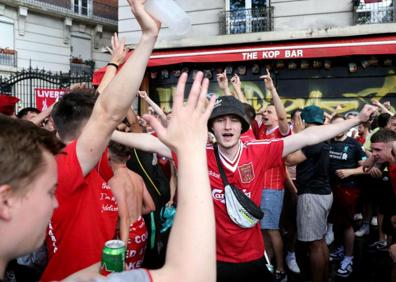 Imagen secundaria 1 - Arriba, el trofeo de la Champions, flanqueado por las camisetas de los dos equipos finalistas. En las otras dos imágenes, aficionados de Liverpool y Real Madrid disfrutando de la fiesta. 